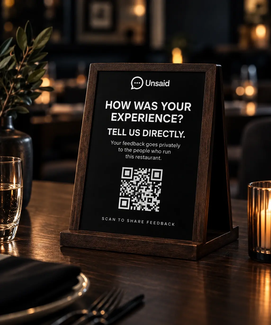 Unsaid QR table sign on a restaurant table — a private way for guests to reach ownership